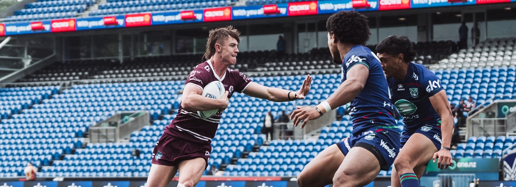 Centre Oliver Lawry fends off the Warriors in Auckland today