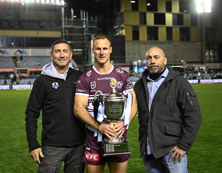 Mat and Don Rogers present Manly captain Daly Cherry-Evans with the Steve Rogers Memorial Trophy, in honour of their late, great father and Sharks Immortal.