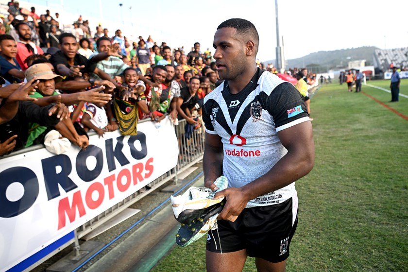 Caleb offering his footy boots to fans in Port Moresby after defeating Cook Islands